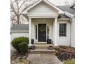 Front entrance with black door, white columns, and potted plants at 1303 Meadowbrook Dr, Indianapolis, IN 46240