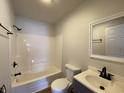 Updated bathroom with a tub, vanity, and dark fixtures at 1608 Edgecombe Ave, Indianapolis, IN 46227