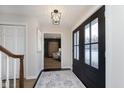 Bright entryway with black French doors and view of living room at 1716 Westwood Dr, Anderson, IN 46011