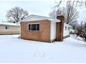 Brick and siding home with chimney, winter yard view at 176 Monroe St, Indianapolis, IN 46229