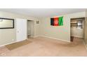Spacious living room with tan carpet, Afghan flag, and muted walls at 3153 Arbutus Dr, Indianapolis, IN 46224