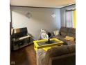 Living room features brown couches, yellow coffee table, and flat-screen TV at 4715 E 33Rd St, Indianapolis, IN 46218