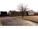 Lovely home exterior featuring a brick facade, siding, and a paved driveway leading to the garage at 6327 E 52Nd Pl, Indianapolis, IN 46226