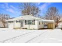 White ranch house with snow covered lawn and carport at 7524 E 48Th St, Indianapolis, IN 46226