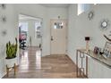 Bright entryway with glass-top console table, hardwood floors, and access to a home gym at 13009 Hartswood Dr, Fishers, IN 46037