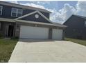 A gray home displays its front elevation and driveway, leading to the two-car attached garage at 251 Dyson Dr, Whiteland, IN 46184