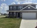 Two-story home with gray siding and a brick facade, enhanced by a well-manicured lawn at 251 Dyson Dr, Whiteland, IN 46184
