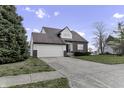 Two-story house with a brick and vinyl exterior, attached garage, and a landscaped yard at 297 Van Buren St, Greenfield, IN 46140