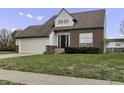 Two-story house with a brick facade, attached garage, and neat lawn at 297 Van Buren St, Greenfield, IN 46140