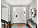 Bright entryway with hardwood floors, a white door, and a modern console table at 3015 Olive Branch Rd, Greenwood, IN 46143