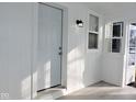 White front door and porch with light fixture at 3153 N Layman Ave, Indianapolis, IN 46218