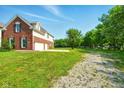 Back of property features an oversized two car garage, ample parking, and mature landscaping at 4450 W 300 N, Fairland, IN 46126