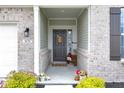 Inviting front porch with a decorative door, potted plants, and brick accents at 5670 Terracotta Trce, McCordsville, IN 46055