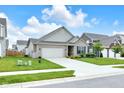 Attractive one-story house with a two-car garage and a green lawn under a partly cloudy sky at 5670 Terracotta Trce, McCordsville, IN 46055