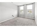 Simple bedroom with gray walls, gray carpet, and two windows at 6305 Primrose Dr, Whitestown, IN 46075