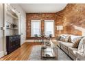 Bright living room with exposed brick wall, hardwood floors, and modern furnishings at 643 Fort Wayne Ave # H, Indianapolis, IN 46204