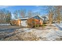 Brick home with attached garage and snowy yard at 8810 W Tulip Tree Dr, Muncie, IN 47304