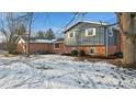 Brick and gray sided home with a snowy yard and large tree at 8810 W Tulip Tree Dr, Muncie, IN 47304