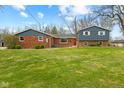 View of home with brick and siding, trimmed bushes in front, and green lawn at 8810 W Tulip Tree Dr, Muncie, IN 47304