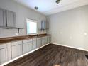 Simple kitchen with gray cabinets and dark wood flooring at 1128 N Holmes Ave, Indianapolis, IN 46222