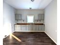 Simple kitchen featuring gray cabinets and dark wood flooring at 1128 N Holmes Ave, Indianapolis, IN 46222