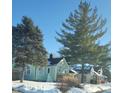 Light green house with white trim, wooden deck, and snowy yard at 135 S 11Th Ave, Beech Grove, IN 46107