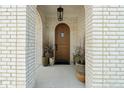 Arched wood front door framed by brick archway and decorative plants at 15844 Nocturne Dr, Westfield, IN 46074