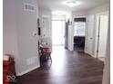 Light-filled entryway with hardwood floors, showing access to bedroom and other rooms at 173 Megan Way, Cumberland, IN 46229