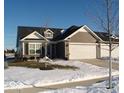 Ranch style home with two-car garage and snow-covered landscaping at 173 Megan Way, Cumberland, IN 46229