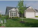 Inviting single-story home with an attached garage, landscaped front yard, and a blend of siding and stone at 173 Megan Way, Cumberland, IN 46229