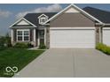 Well-maintained single-story home featuring an attached garage, manicured lawn, and inviting front entrance at 173 Megan Way, Cumberland, IN 46229