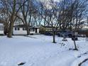 A cozy home featuring a snowy front yard and black window shutters at 3951 N Pasadena St, Indianapolis, IN 46226