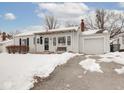Ranch home with covered porch and attached garage, snow-covered yard at 5150 Atherton N Dr, Indianapolis, IN 46219