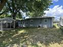 A quaint backyard featuring a covered patio area, grassy space, and mature trees at 835 E Berwyn St, Indianapolis, IN 46203