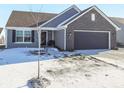 Inviting single-Gathering home with gray siding, brick accents, and a well-kept lawn covered in snow at 943 Aurora Ln, Franklin, IN 46131