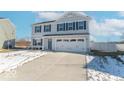 Two-story house with gray siding, a two-car garage, and a snow-covered front yard at 13781 N Rising Sun E Cir, Camby, IN 46113