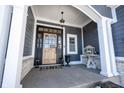 Elegant front entrance with a wooden door, black frame, and a stone porch at 15744 Bethpage Trl, Carmel, IN 46033