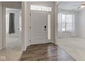 Bright entryway featuring wood floors, white front door with glass and adjacent living spaces at 15759 Hargray Dr, Noblesville, IN 46062