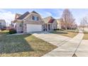 Lovely home showcasing a well-maintained lawn, spacious driveway, and classic architectural details at 15759 Hargray Dr, Noblesville, IN 46062