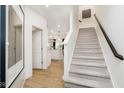 Modern staircase with light gray carpeting and dark wood railing at 18721 Moray St, Westfield, IN 46074