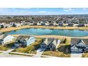 Aerial view of a community with a pond, showcasing the neighborhood layout and surrounding landscape at 19226 English Lake Ln, Noblesville, IN 46062