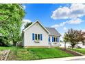 Quaint single-story house with blue shutters, complemented by a beautiful lawn and landscaping at 207 E Ohio St, Fortville, IN 46040