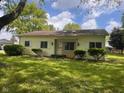 A single-story home featuring a landscaped front yard and light yellow siding at 208 Winding Dr, Alexandria, IN 46001