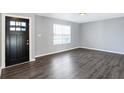 Empty living room with dark gray vinyl flooring and black door at 2911 Braxton Ct, Indianapolis, IN 46229