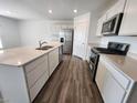 Modern kitchen featuring stainless steel appliances, white cabinetry, an island, and hardwood floors at 3231 W Keepsake Ln, Monrovia, IN 46157