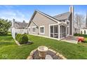 Well-maintained backyard with a screened-in porch, lush lawn, and a quaint patio area perfect for outdoor relaxation at 3543 Clearwater Cir, Indianapolis, IN 46240