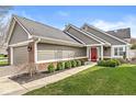 Charming home featuring a red front door, manicured lawn, neutral siding, and a brick accent for a welcoming curb appeal at 3543 Clearwater Cir, Indianapolis, IN 46240