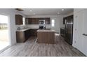 Spacious kitchen with stainless steel appliances, central island, and wood grain flooring at 3945 Highcrest Rd, Indianapolis, IN 46239