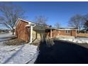 Side view of brick ranch house with attached garage and snowy yard at 407 Hawthorne Ln, Greenfield, IN 46140