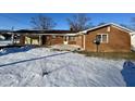 Brick ranch house with attached garage, patio, and snowy yard at 407 Hawthorne Ln, Greenfield, IN 46140